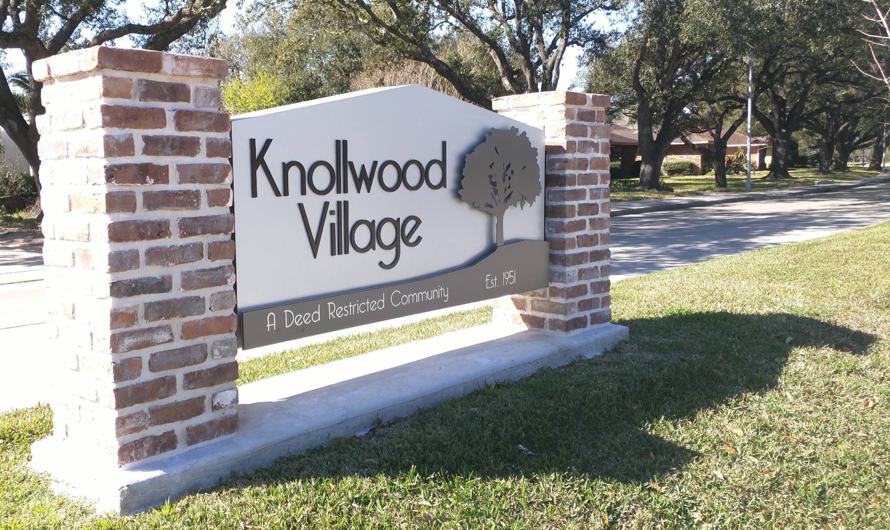 Knollwood Village entrance sign, brick columns under live oaks