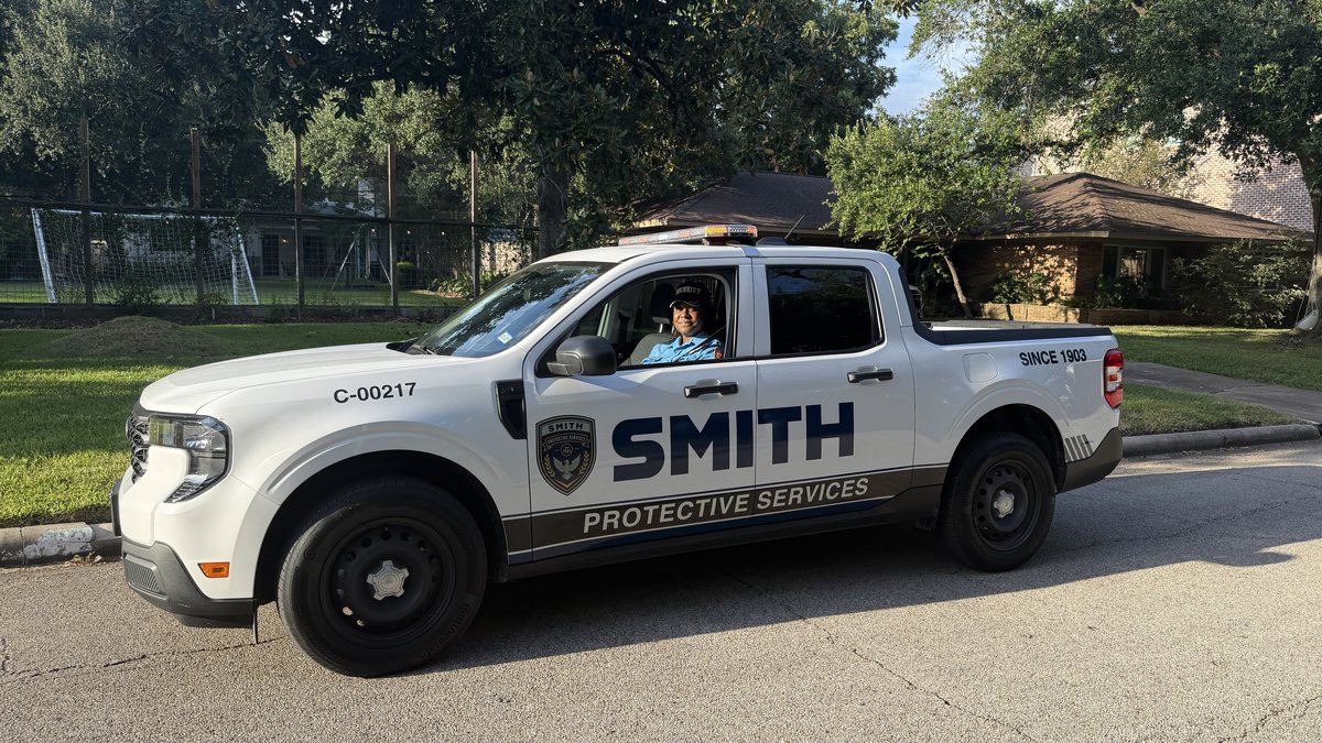 Smith Protective Services patrol vehicle parked on a Knollwood Village street with the officer at the wheel